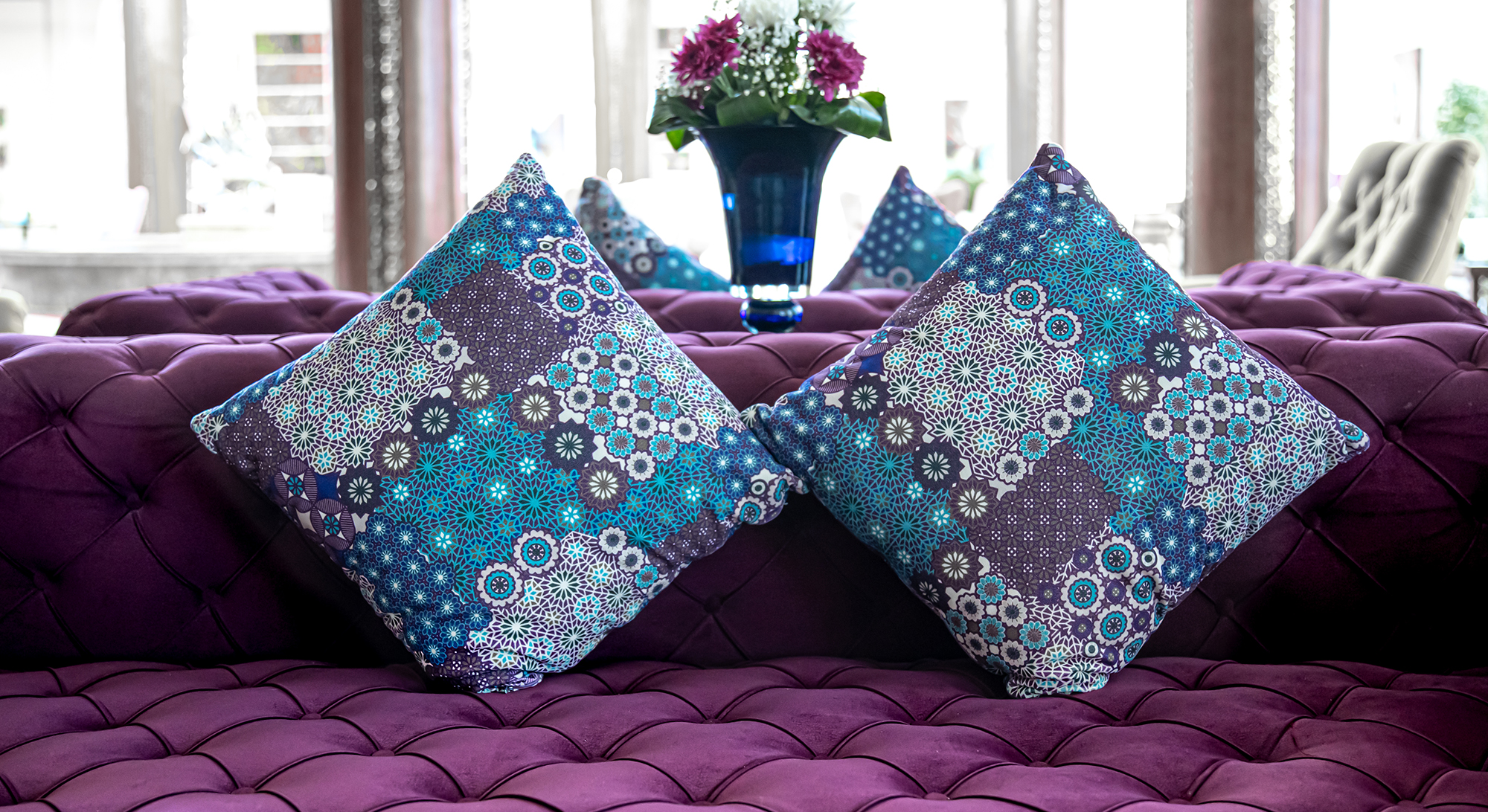 Purple velvet fabric modern sofa with sunken buttons and colorful decorative pillows. Idea and variant of fabric for upholstery sofa.